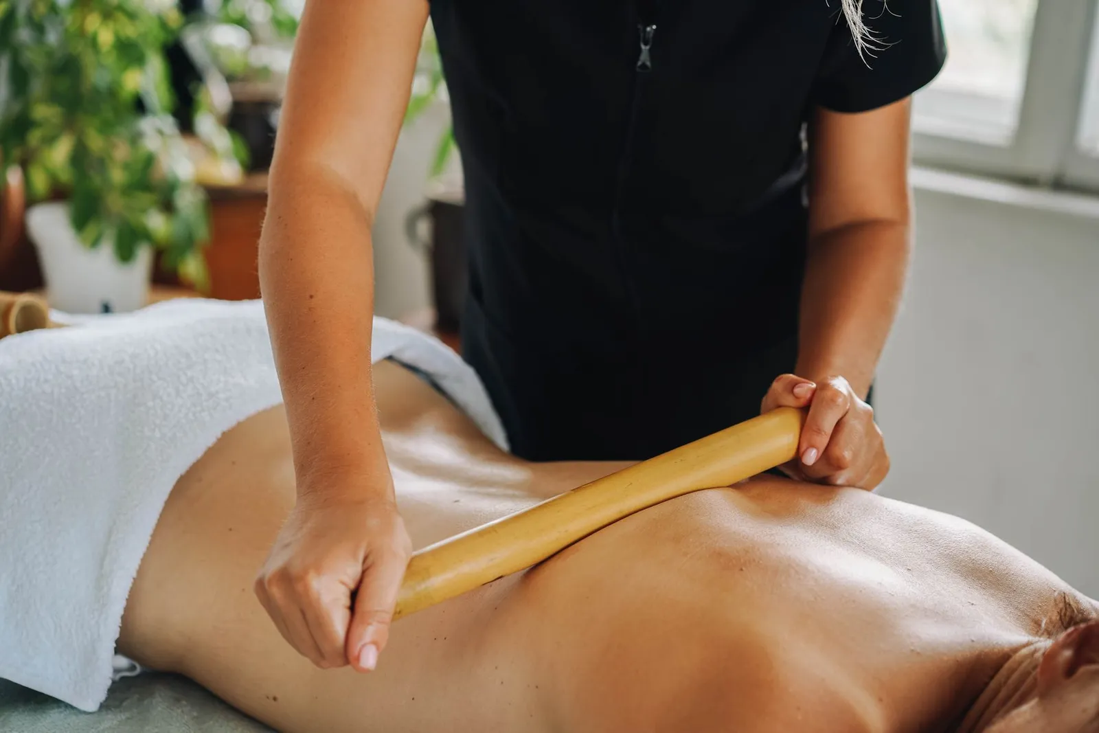 A bamboo-stick massage in a bright spa room (illustrative photo)